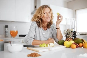 fruit salad and apple with a senior woman in the kitchen of her home for health, diet or nutrition