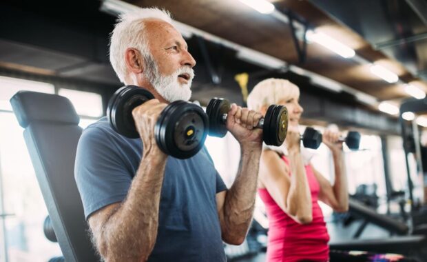 happy senior people doing exercises in gym to stay fit - cholesterol levels