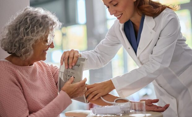 senior woman getting her blood pressure measured by pharmacist in drugstore