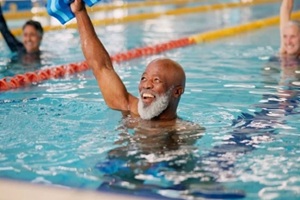 training and mature man in swimming pool for exercise, healthy body and strong muscle