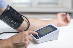 man in a shirt measures blood pressure with an electronic tonometer