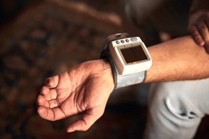 man checking blood pressure and heart rate at home with a portable modern digital meter