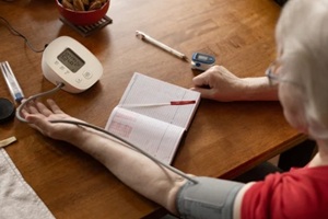 pensioner monitors his blood pressure at home using a tonometer, hypertension and hypotension