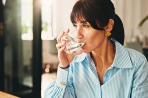 women drinking a glass of water